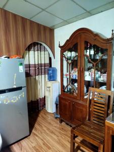 a kitchen with a refrigerator and a wooden cabinet at Mount crest homestay in Kandy