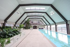 an indoor pool with plants and a building with windows at Paxtonz Exsim By NexxField in Petaling Jaya