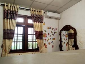 a room with curtains and a table and a window at Mount crest homestay in Kandy