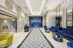 a lobby of a building with blue furniture and chandeliers at Paxtonz Exsim By NexxField in Petaling Jaya +185 photos