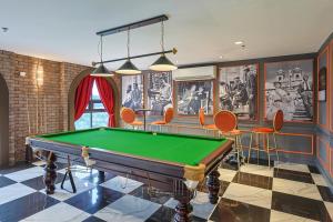 a room with a pool table and chairs at Paxtonz Exsim By NexxField in Petaling Jaya