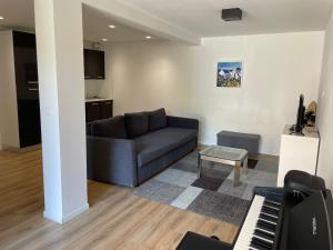 ein Wohnzimmer mit Sofa und Klavier in der Unterkunft Hoeilaart in Hoeilaart