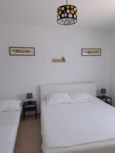 two beds in a room with white walls at Villa Marina in Poljica