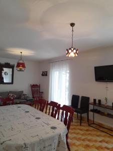 a dining room with a table and chairs and a television at Villa Marina in Poljica