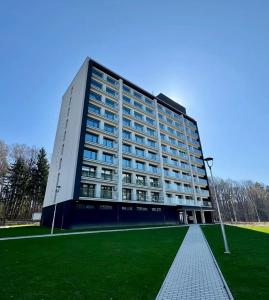 a large building with a green lawn in front of it at Apartmán podlesí in Havířov