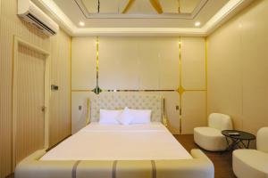a bedroom with a bed and two chairs at Celestia Hue Villa in Hue