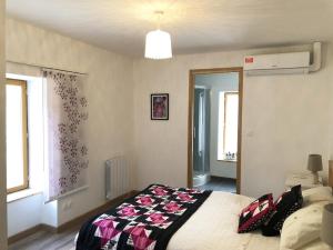 a bedroom with a bed with a blanket on it at Gite Julie Anne in Ussat