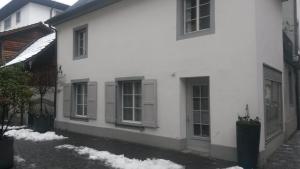 a white house with windows and snow on the ground at Tell Apartments Stans in Stans