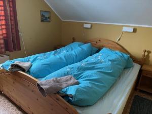 ein Bett mit blauen Laken in einem Schlafzimmer in der Unterkunft Bogstrand, Dverbergveien 11, 8485 Dverberg in Dverberg