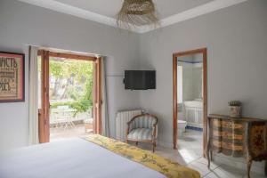 a bedroom with a bed and a television and a chair at Villa Dora in Jávea