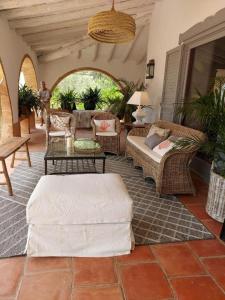 a living room with wicker furniture and a table at Villa Dora in Jávea +82 photos