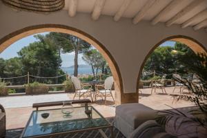 a living room with a glass table and a patio at Villa Dora in Jávea