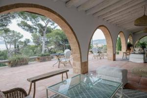 an outdoor patio with a glass table and chairs at Villa Dora in Jávea