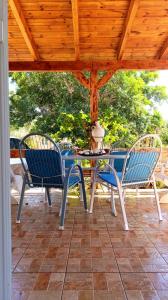 three chairs and a table on a patio at Anavyssos Serenity Villa in Anavyssos