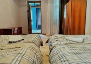 two beds sitting next to each other in a bedroom at Madisha's Guesthouse in Mestia