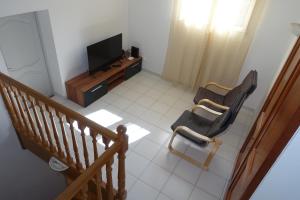 a living room with two chairs and a television at Chambre dans maison provençale avec piscine in Cavaillon