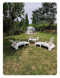 a group of chairs and a table in a field at Les pieds dans l'eau Tente transparente in Fleurville +12 photos