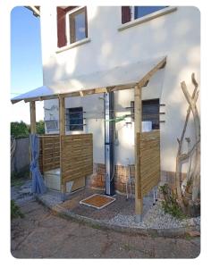 a shower under a building with a wooden structure at Les pieds dans l'eau Tente transparente in Fleurville