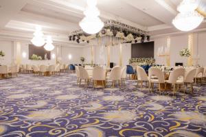 a ballroom with tables and chairs on a blue and gold carpet at Golden Tulip Amman in Amman +53 photos
