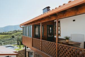 a house with a balcony with a view of a vineyard at Provesende Douro Villas - Casa Principal in Provesende