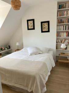 a white bedroom with a bed and a book shelf at Ty Moune in Crach +20 photos