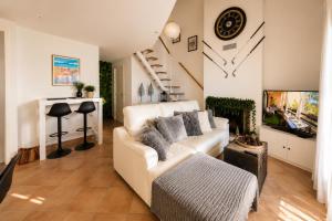 a living room with a white couch and a tv at Lo Exclusive Lisboa - Apartament with terrace and golf view in Charneca