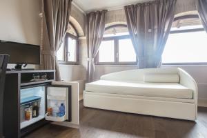 a bedroom with a large white bed and a tv at Il Fortino in Celano
