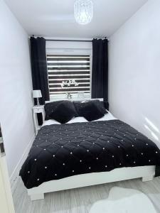 a bedroom with a bed with a black comforter at Apartament Borys in Malbork