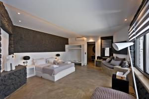 a living room with a bed and a couch at Topos Exclusive Santorini in Imerovigli