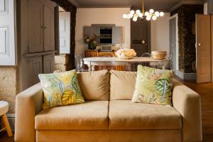 a couch in a living room with a kitchen at Provesende Douro Villas - Casa Principal in Provesende