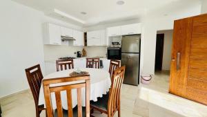 a kitchen with a table and chairs and a refrigerator at Corail in Djerba