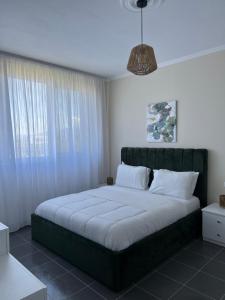 a bedroom with a large bed with a large window at Andrra Apartment - Talea Coast in Lezhë