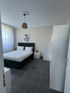 a bedroom with a bed with a green headboard at Andrra Apartment - Talea Coast in Lezhë +4 photos