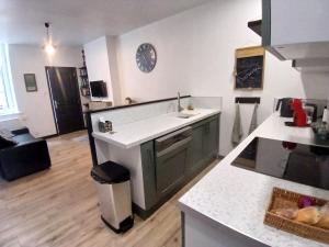 a kitchen with a sink and a clock on the wall at Apartment with a garden in Moulins
