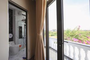 a bathroom with a glass door leading to a balcony at Celestia Hue Villa in Hue +21 photos