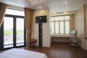 a hotel room with a bed and a desk and window at Celestia Hue Villa in Hue