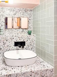a bathroom with a white tub on a floral tile wall at Koufeto in Kondoyenádha +44 photos