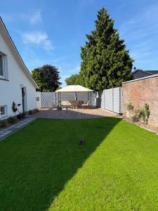 a backyard with a lawn with a table and a fence at Karolinger Stay in Emmerich