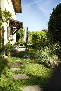 a garden with a walkway with a table and an umbrella at The Comfy Apartment in Ponte Capriasca