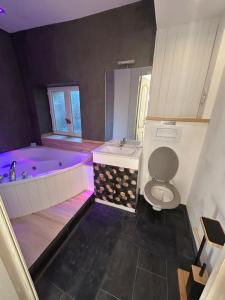 a bathroom with a tub and a toilet and a sink at le nid gourmand in Andryes
