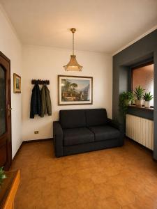 a living room with a black couch in a room at Sa Omu 'e Pinucciu in Lanusei