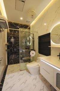 a bathroom with a toilet and a glass shower at Celestia Hue Villa in Hue