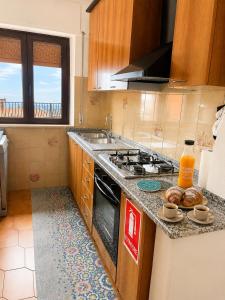 a kitchen with a counter top with a stove top oven at Sa Omu 'e Pinucciu in Lanusei