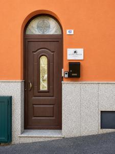 a brown door on a building with an orange wall at Sa Omu 'e Pinucciu in Lanusei