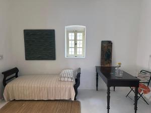 a room with a bed and a desk and a table at Mylopotamos House in Milopótamos