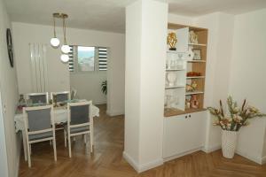 a white dining room with a table and chairs at Ari's Arpartament in Beiuş