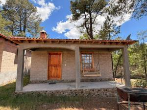 a small house with a red door and a porch at Cabañas sierra grande in Creel