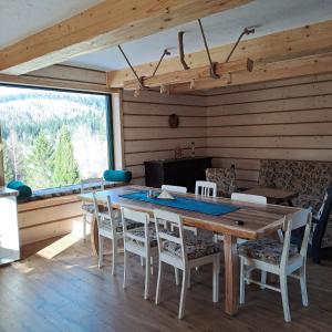 a dining room with a wooden table and chairs at Chata pod Jelenim Skokiem in Cisna