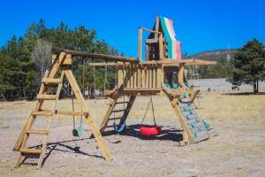 a wooden playground with a ladder and a swing at Cabañas sierra grande in Creel +17 photos