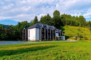 a building on a hill with a grass field at Mira Montis in Borşa